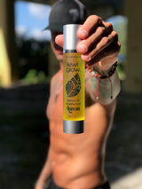 “Kavai Tattoo Oil by Kiwi Glow held by tattooed man outdoors – natural tattoo moisturizer”