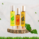 Trio of Kiwi Glow oils on natural wood with foliage—small-batch, sesame-oil moisturizers for face, body, and tattoo care.