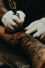 Tattoo Artist performing needlework on arm